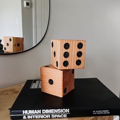 two wooden dices are stacked on top of each other in front of a mirror