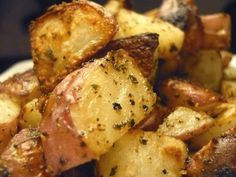 closeup of cooked potatoes with seasoning on them in a white bowl, ready to be eaten