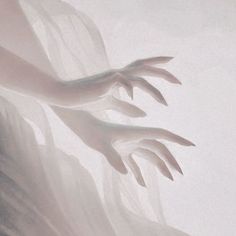 two hands reaching towards each other in front of a foggy wall with white walls