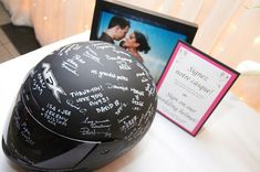 a motorcycle helmet with autographs on it next to a framed photograph and a tablet