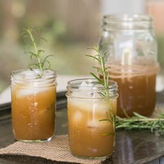 three jars filled with drinks sitting on top of a table