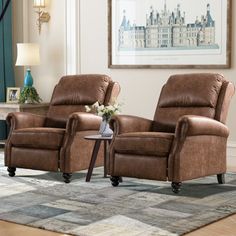 two brown leather recliners sitting on top of a rug