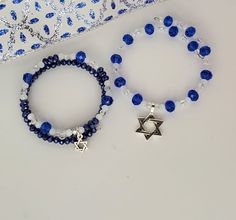 "A beautiful Hanukkah beaded bracelet of sparkling glass crystal beads in the holiday's traditional colors of blue and white. A silver charm of the Star of David hangs gracefully from the bracelet, celebrating the annual Jewish festival of lights, a celebration of miracles and blessings. Made with stainless steel memory wire, these bracelets wrap simply and gently around your wrist - no clasp required. And they fit most sizes comfortably. Wear as a stand-alone piece or stack with other Christmas Group Bracelets, Hanukkah Jewelry, Daughter Bracelets, Mother Daughter Bracelets, Holiday Bracelets, Holiday Hostess Gifts, Jewish Jewelry, Mother Daughter Gifts, Presents For Women