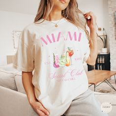 🌟 Embrace our Miami Social Club Shirt! This tee is perfect for anyone who loves cocktails or appreciates aesthetic shirts! Treat yourself or surprise a friend with this thoughtful gift!  👕 COMFORT COLORS 1717 T-SHIRT The Comfort Colors 1717 garment-dyed unisex t-shirt is made with medium fabric consisting of high quality, 100% ring-spun US cotton for long-lasting comfort. All shirts feature pre-shrunk cotton for size retention and a signature sewn-in twill label. 👕 SIZING & CARE Shirt runs tr Miami Girls Trip, Bach Gift, Bachelorette Merch, Miami Shirt, Miami Girls, Miami Beach Florida, Aesthetic Shirts, Club Shirts, Social Club