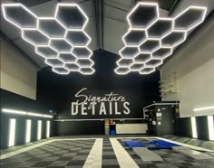 the entrance to signature details is lit up with lights and checkered tile flooring