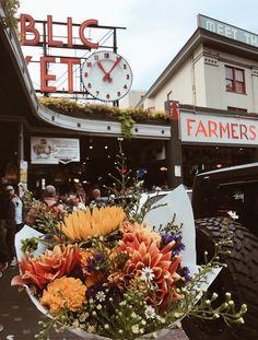 a large bouquet of flowers sitting on top of a table in front of a building