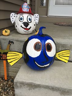 two pumpkins decorated to look like fish on the steps