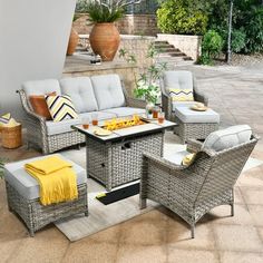 an outdoor living room with wicker furniture and yellow throw pillows on the patio floor