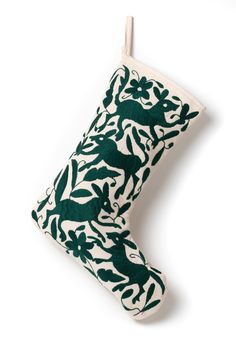 a green and white christmas stocking hanging from a hook on a white background,