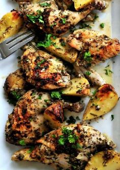 grilled chicken and potatoes on a white plate with a fork in the middle, garnished with parsley