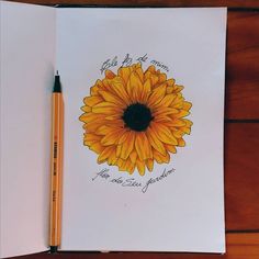 an open notebook with a drawing of a sunflower on it and a pencil next to it