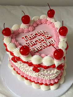 a heart shaped birthday cake with cherries on top and the words happy birthday written in frosting