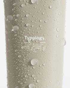 water drops on the side of a white bottle with typollogy written in it