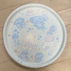 a blue and white plate with jellyfish on it sitting on a wooden table top