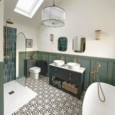 a bathroom with two sinks, a toilet and a bathtub