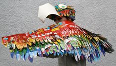 a man wearing a paper mache costume made out of coca - cola cans and papers