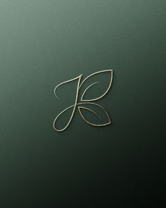 the letter k is made out of gold wire and has a leaf on it's side