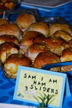 there are many small sandwiches in the trays on this blue tablecloth with a sign that says sami am swiderrs