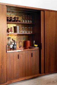 a wooden cabinet filled with lots of bottles and glasses