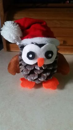 an owl wearing a santa hat and pine cones