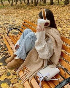 a woman is sitting on a bench with her coffee