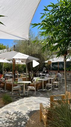 an outdoor dining area with tables and umbrellas