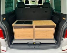 the back end of a van with an open trunk and two wooden drawers in it