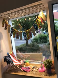 a window sill filled with lots of toys next to a flag and other items