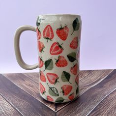 a ceramic mug with strawberries on it