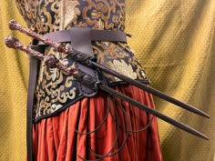 a costume with two swords attached to it's back and an elaborate belt around the waist