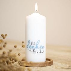 a white candle sitting on top of a wooden table