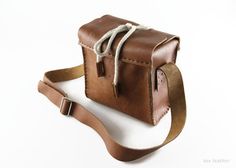 a brown leather bag sitting on top of a white table