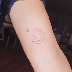 a person with a small tattoo on their arm that has a crescent moon and star