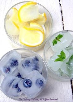 three plastic bowls filled with ice and lemon slices on top of a white wooden table