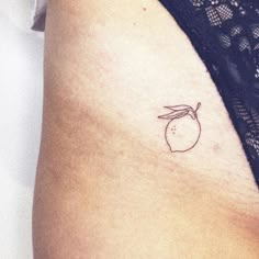 a woman's arm with a small apple tattoo on the left side of her thigh