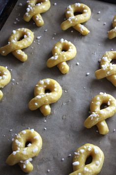 pretzels with white sprinkles are on a baking sheet ready to go into the oven