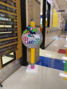 a sign that is on the ground in front of a school hallway with colorful stripes