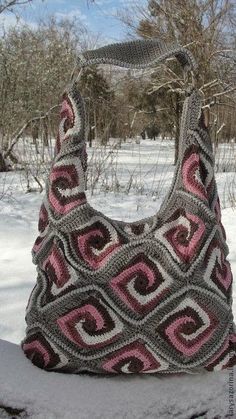 a crocheted purse sitting in the snow