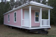 a tiny pink house sitting on top of a trailer