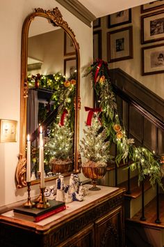 a christmas scene with candles and decorations on a table in front of a large mirror