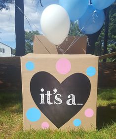 a cardboard box with balloons in the shape of a heart and it's a sign