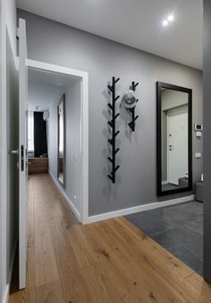 an empty room with wood flooring and mirrors on the wall, in front of a mirror