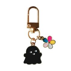 a keychain with a black ghost on it and a flower charm attached to it