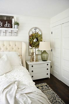 a white bed sitting in a bedroom next to a dresser