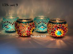 there are three glass jars with mosaic designs on them, one is blue and the other is red