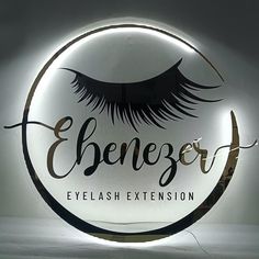 an illuminated sign that says eyelash extension on the front and side of it with long eyelashes