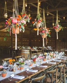 the tables are set with flowers and hanging vases