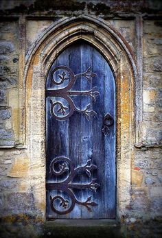 an old wooden door with iron work on it