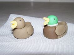 two rubber ducks sitting on top of a white cloth