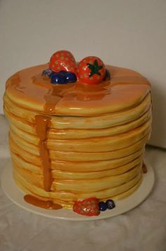 a stack of pancakes sitting on top of a white plate covered in orange icing